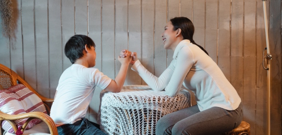 Mother and son arm wrestling